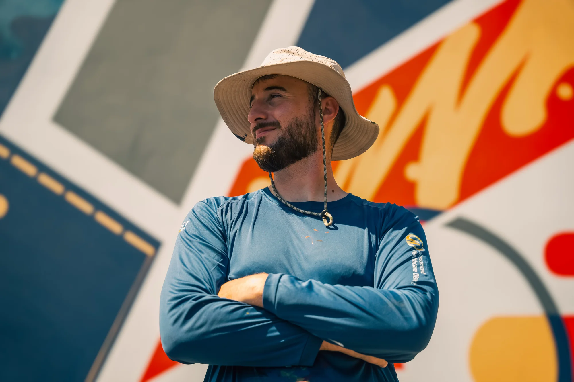 Julien, founder and lead artist of Pezer97 Studios, in front of a large-scale mural in progress