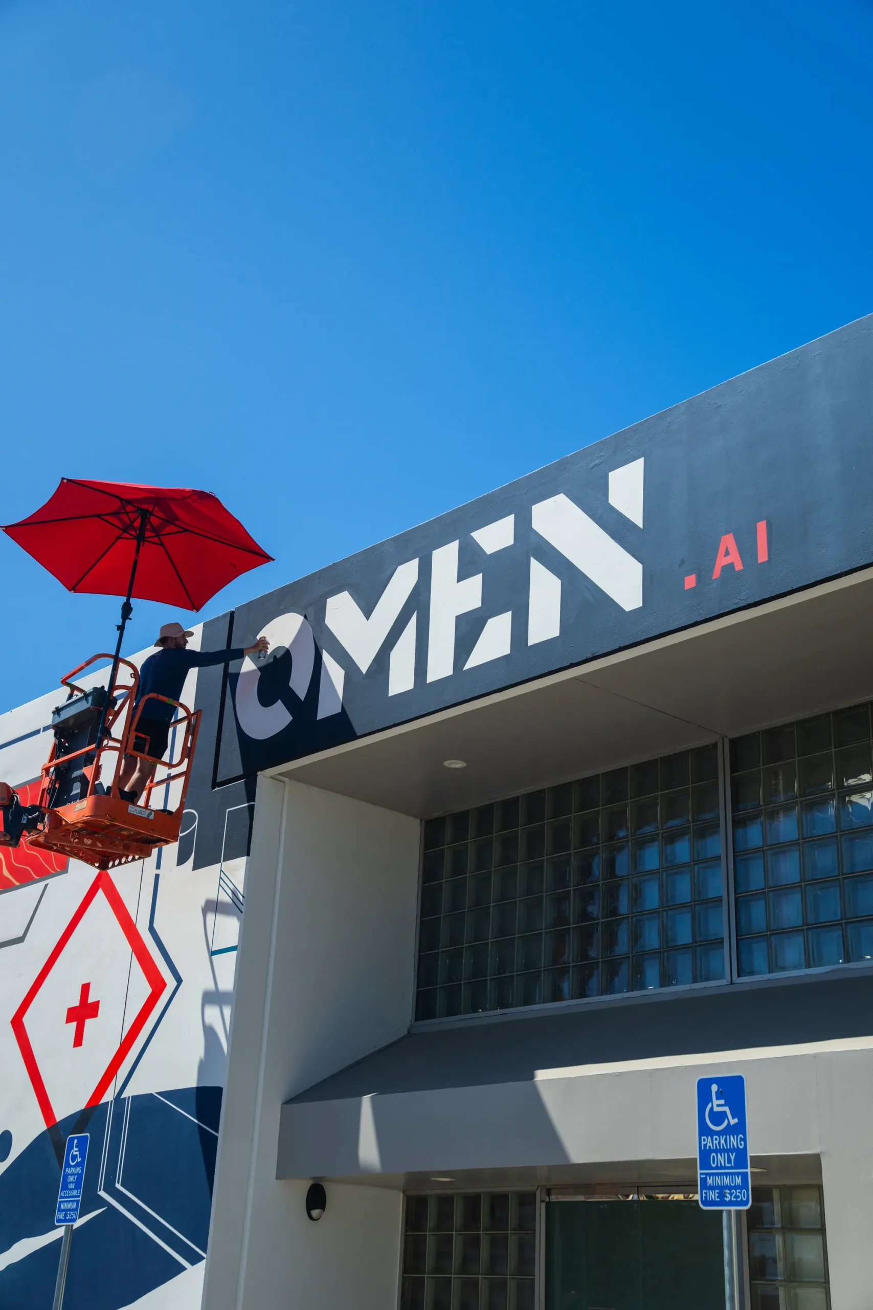 Omen AI building signage alongside the hand-painted mural facade by Pezer97 Studios